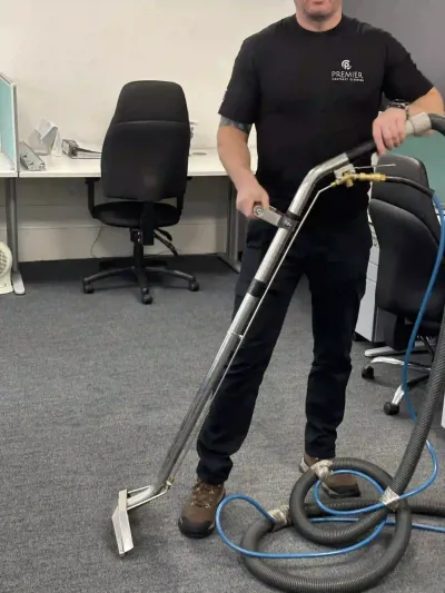 Premier technician cleaning office carpet with an extraction wand