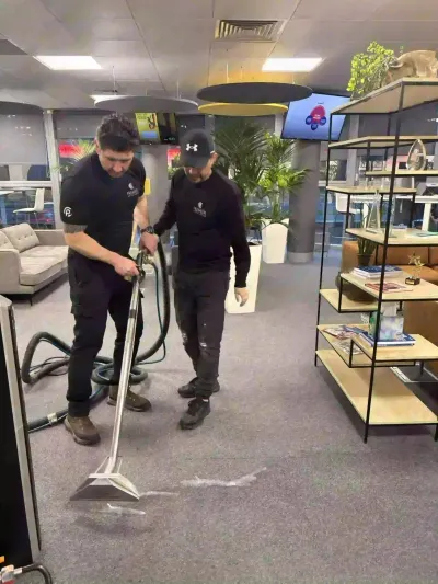 Two Premier technicians carpet cleaning a showroom