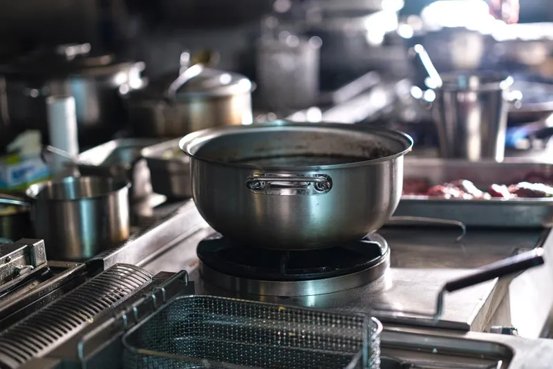 Stainless steel pots on a commercial kitchen range