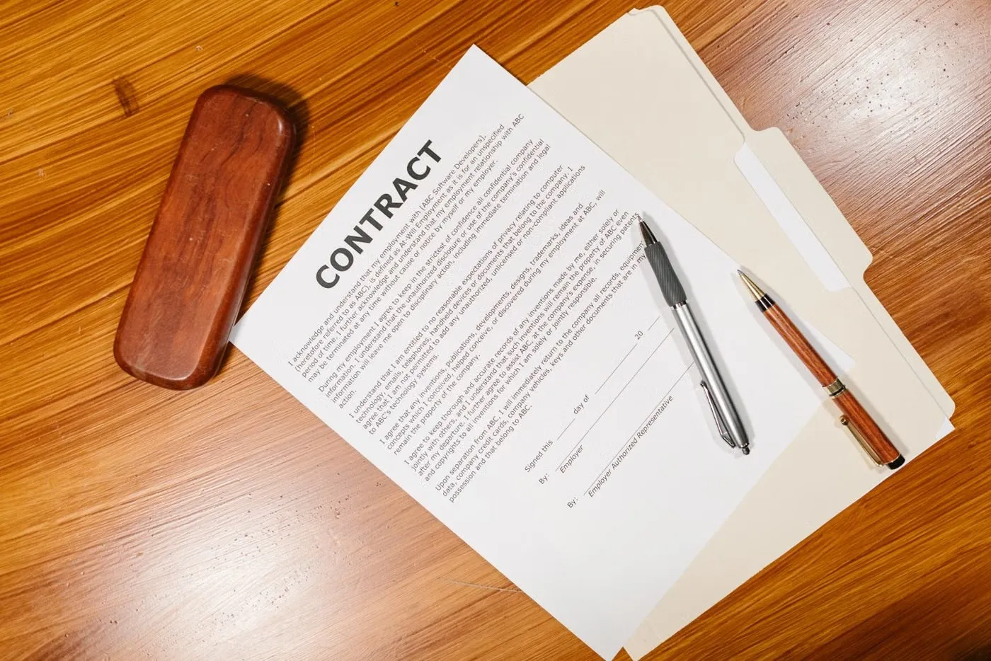 Contract document with pens on a wooden desk