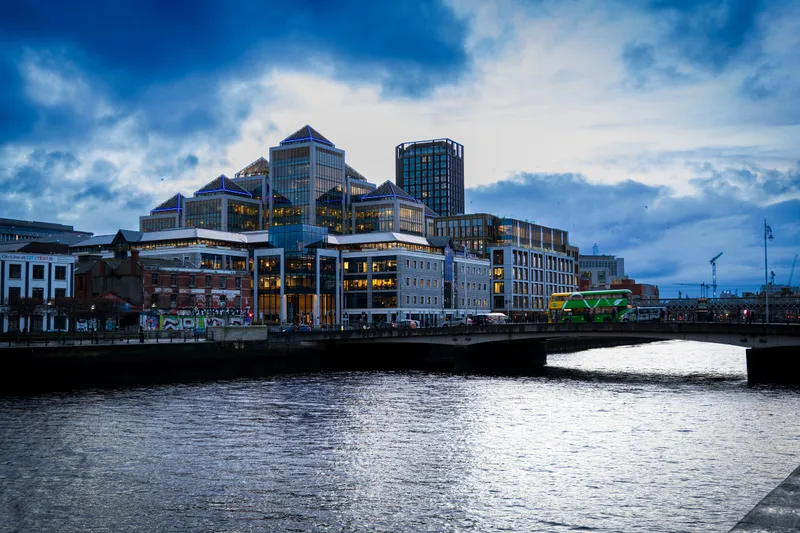 Glass office buildings beside the River Liffey in Dublin at dusk