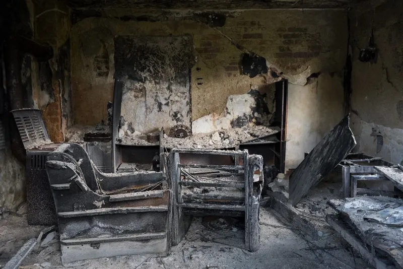 Room with soot-covered walls and fire-damaged furniture