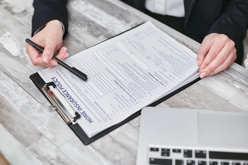 Person reviewing an insurance policy on a clipboard