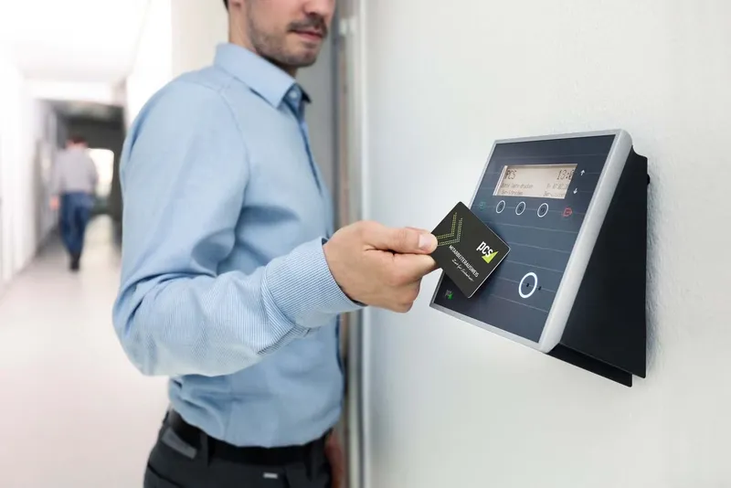 Man holding a key card to an office access reader