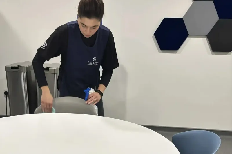 Premier cleaner wiping a meeting room table