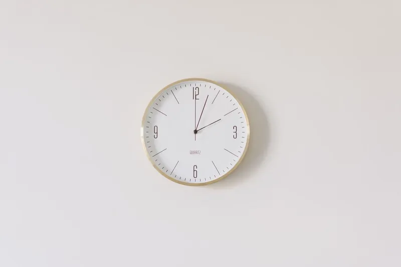 Round wall clock on a white wall