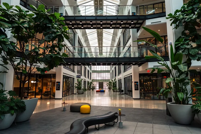 A bright atrium with seating and plants in a managed office building