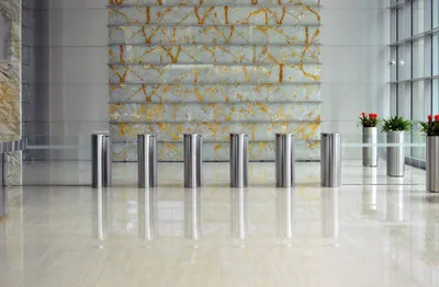 A polished marble office lobby with stainless steel security gates