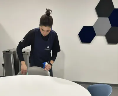 Premier cleaner wiping down a meeting room table