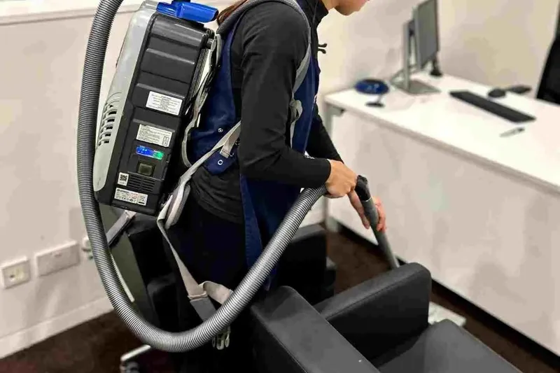 Premier cleaner vacuuming an office with a backpack vacuum