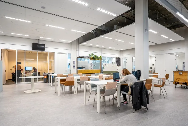 Modern open-plan office with people working at tables