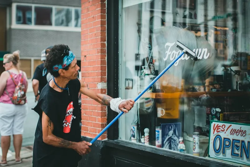 Window cleaner using a squeegee on a shopfront window