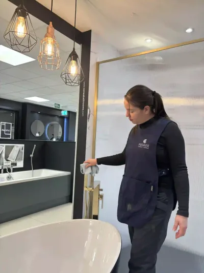 Premier cleaner wiping a basin unit in a bathroom showroom