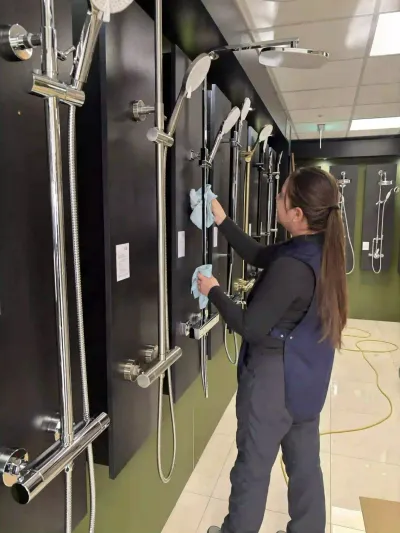 Premier cleaner wiping a wall of shower displays