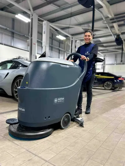 Premier cleaner using a scrubber dryer on a car showroom floor