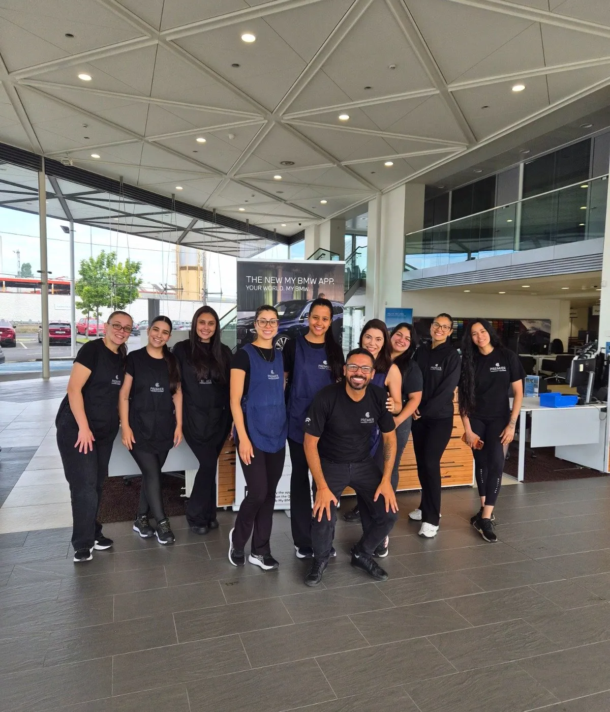 The full Premier team in uniform at a client's car showroom