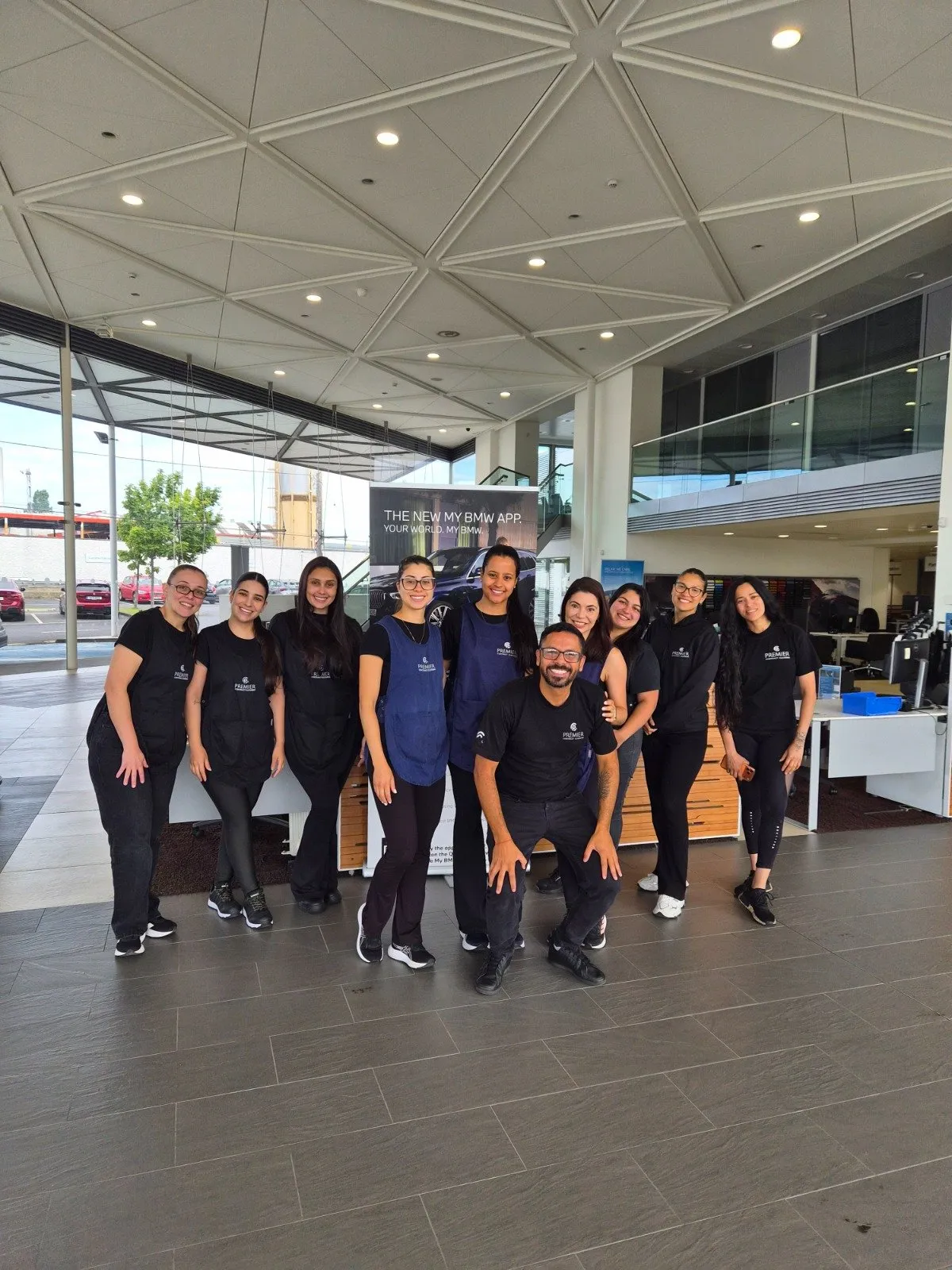 The full Premier team in uniform at a client's car showroom
