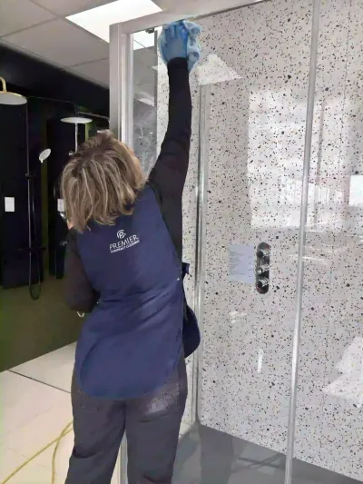 Premier cleaner cleaning a shower screen on display
