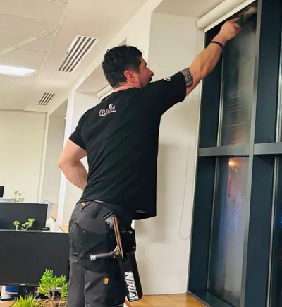 Premier cleaner squeegeeing a tall office window