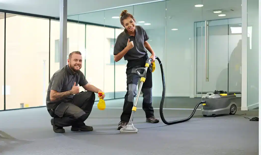 Two people are cleaning the carpet with smiling faces