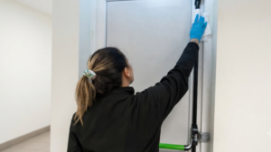 Vetted cleaning operative in hi-vis arriving at an office door at night with ID ready for after-hours clean in Dublin